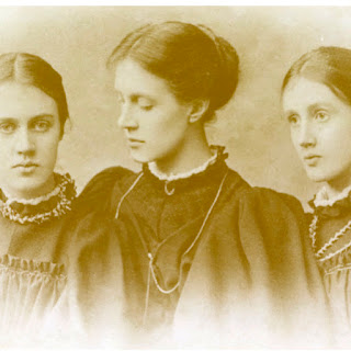 Vanessa Bell, Virginia Woolf, Stella Duckworth: Fotografia antiga em tons de sépia retratando três mulheres jovens, as irmãs Stephen (Vanessa, Virginia e Stella), com trajes de época.