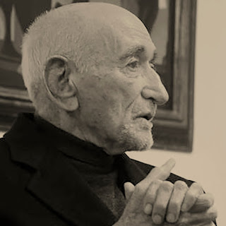 Ariano Suassuna: Retrato de perfil em tons sépia de um homem idoso e calvo, com as mãos entrelaçadas.