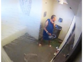 Man in smock in prison isolation cell