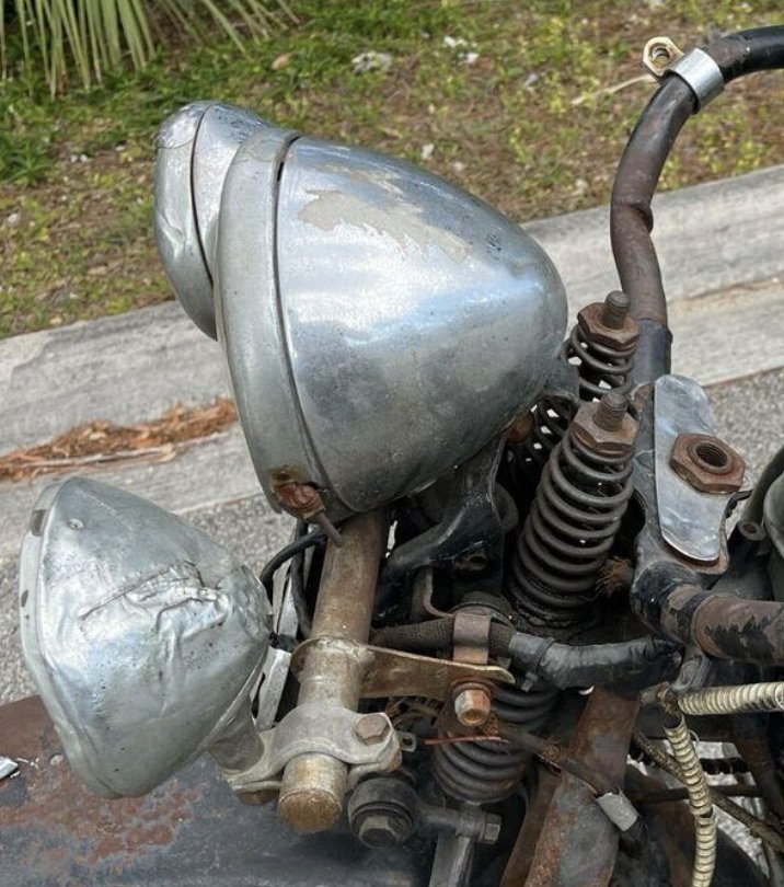 Close-up de faróis e suspensão dianteira de uma motocicleta antiga e enferrujada