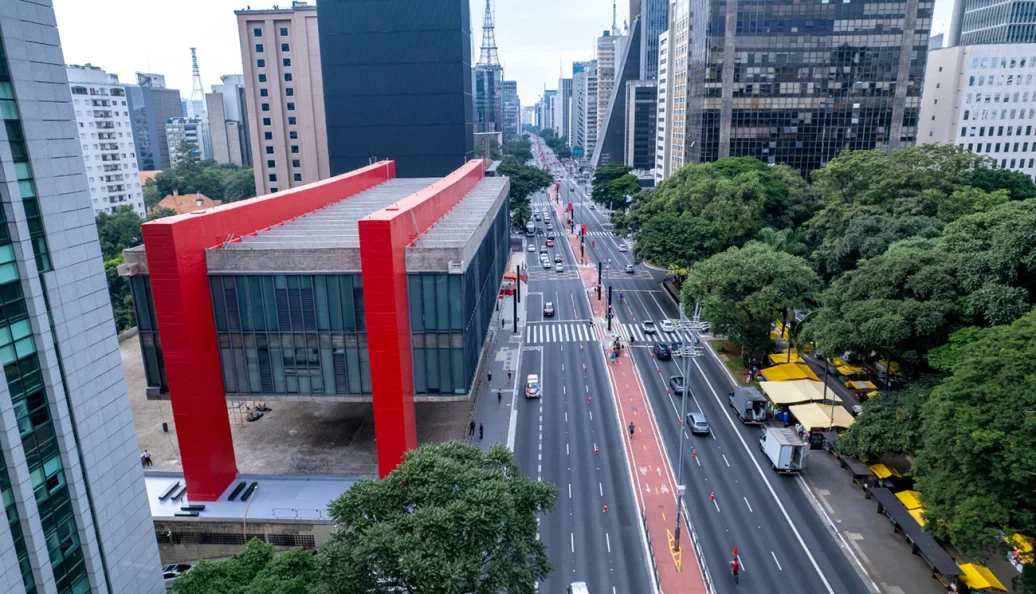 Vista aérea da Avenida Paulista em São Paulo, com destaque para o Museu de Arte de São Paulo (MASP) e o fluxo de veículos e ciclovia.