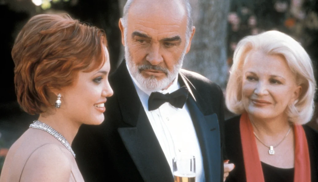 Angelina Jolie, Sean Connery, Gena Rowlands: Cena do filme 'Corações Apaixonados' (Playing by Heart) com três atores em trajes formais.