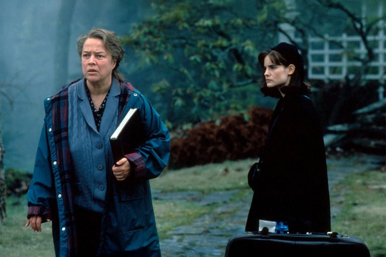 Kathy Bates, Jennifer Jason Leigh: Cena do filme Dolores Claiborne mostrando as duas protagonistas em um ambiente externo nublado.