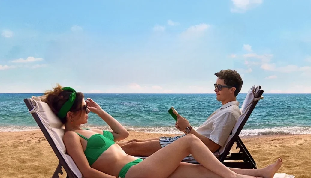 Lana Condor, Chris Fulton: Uma fotografia de dois jovens, um homem e uma mulher, relaxando em espreguiçadeiras na praia com o oceano ao fundo. O homem segura um livro.