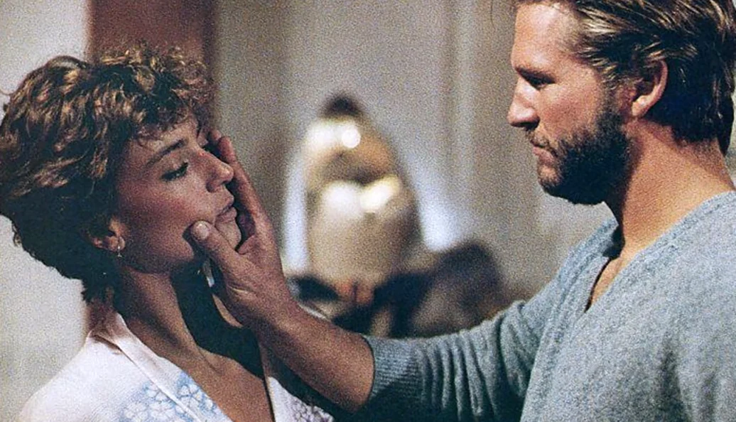 Jeff Bridges, Karen Allen: Uma cena do filme Starman, mostrando Jeff Bridges segurando o rosto de Karen Allen.