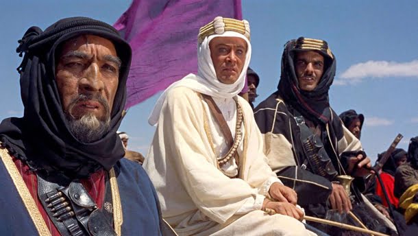 Anthony Quinn, Peter O'Toole, Omar Sharif: Cena do filme Lawrence da Arábia mostrando Anthony Quinn, Peter O'Toole e Omar Sharif em vestes árabes tradicionais no deserto.