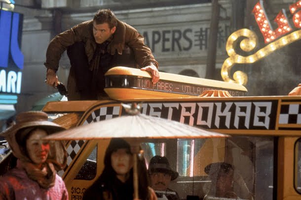 Harrison Ford: Harrison Ford como Rick Deckard em cima de um veículo em cena do filme Blade Runner