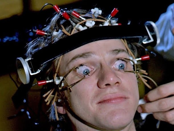 Malcolm McDowell: Cena do filme Laranja Mecânica onde o personagem Alex DeLarge é submetido ao Tratamento Ludovico com os olhos forçados a permanecerem abertos.