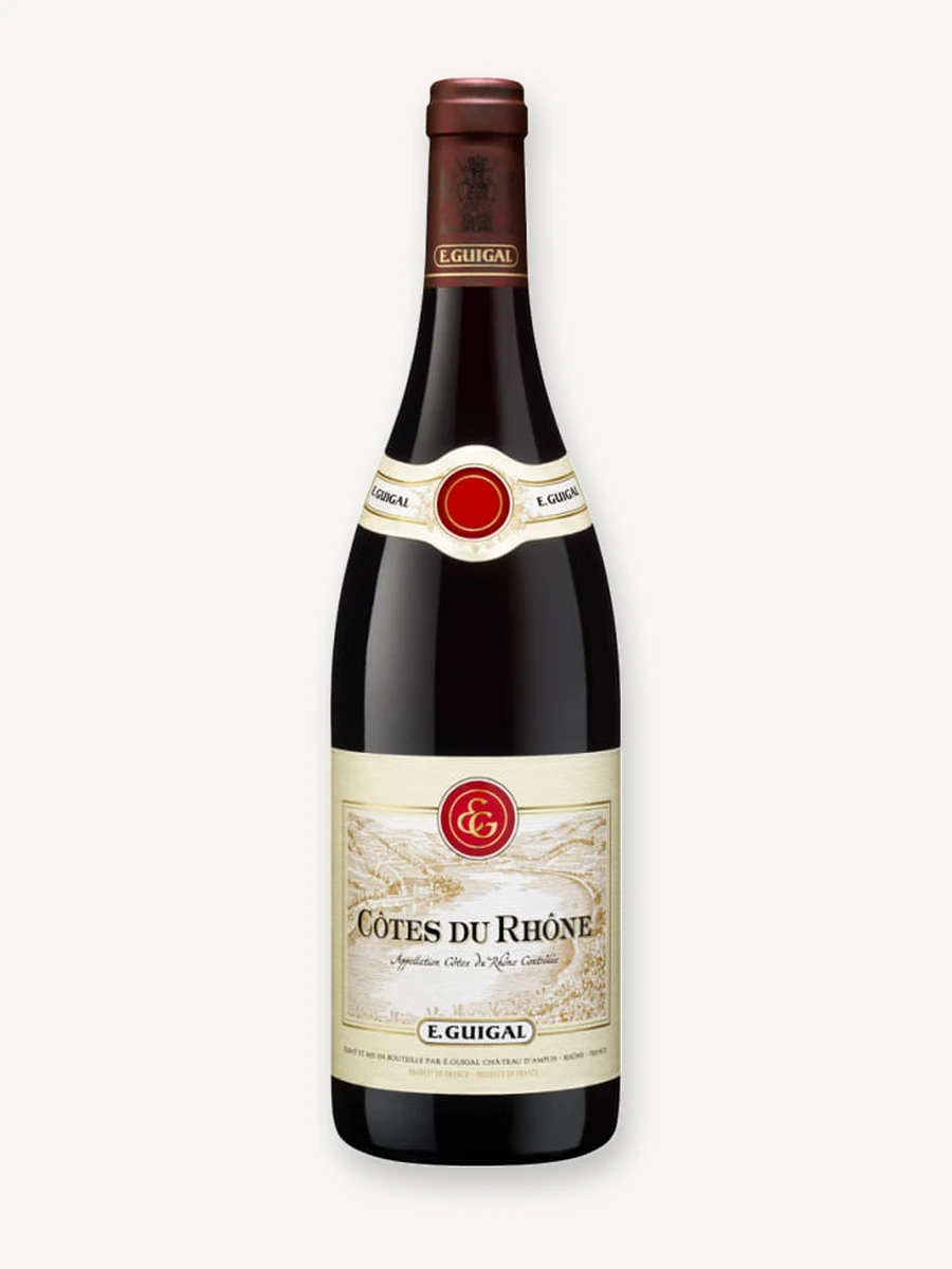 Uma garrafa de vinho tinto E. Guigal Côtes du Rhône sobre um fundo claro.