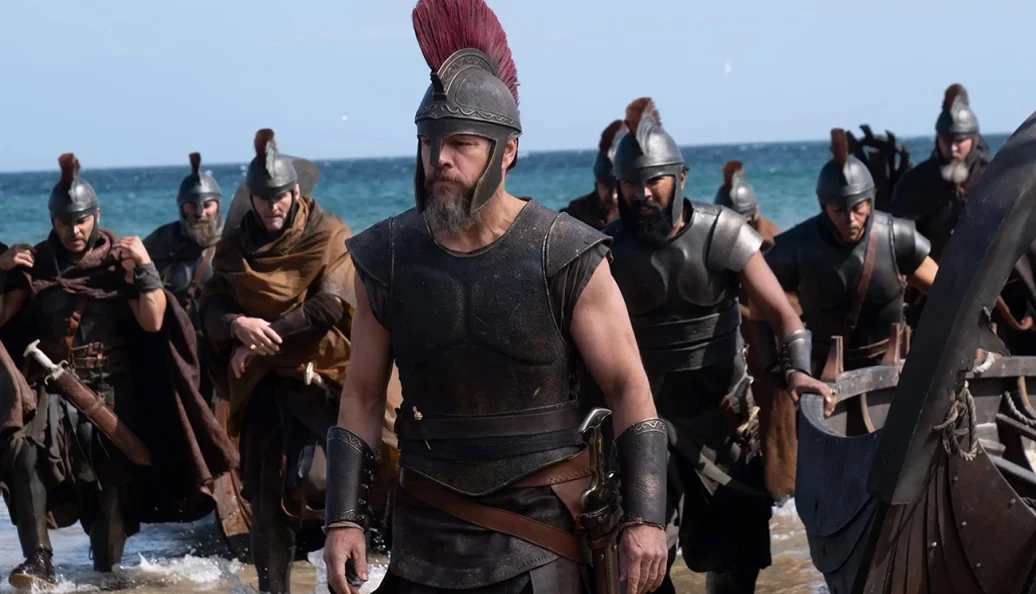 Matt Damon: Cena de filme mostrando soldados espartanos ou gregos antigos desembarcando em uma praia.