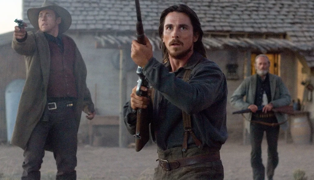 Christian Bale, Russell Crowe: Cena do filme de faroeste 3:10 to Yuma, mostrando homens armados em frente a uma construção de madeira.