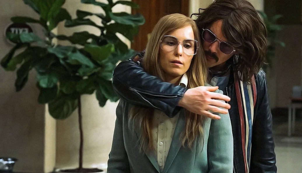 Noomi Rapace, Ethan Hawke: Cena do filme Stockholm com um homem segurando uma mulher por trás.