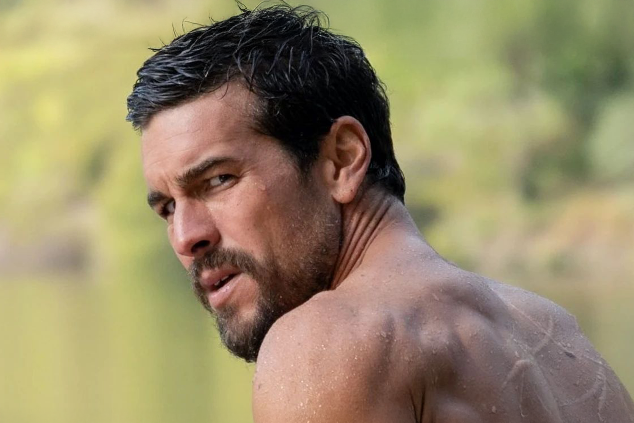 Mario Casas: Retrato de um homem com barba e cabelos escuros, olhando por cima do ombro, com marcas de cicatrizes nas costas.