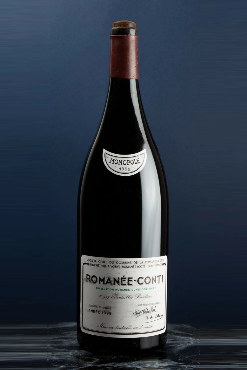 Uma garrafa de vinho Romanée-Conti 1999 em fundo azul escuro.