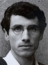 António Feio: Retrato em close-up de um homem jovem com óculos redondos e cabelos escuros e encaracolados.