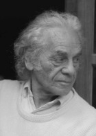 António Ramos Rosa: Retrato em preto e branco de um homem idoso com cabelos claros e cacheados, vestindo uma camisola ou camisola de gola redonda.
