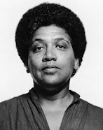 Audre Lorde: Retrato em preto e branco de uma mulher com cabelo estilo afro.