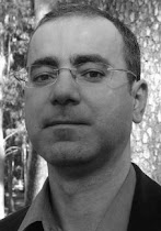 Gonçalo M. Tavares: Retrato em preto e branco de um homem usando óculos.