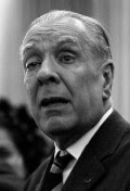 Jorge Luis Borges: Retrato em close-up de um homem idoso em preto e branco, vestindo terno e gravata.