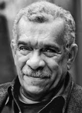 Derek Walcott: Retrato em close-up e em preto e branco de um homem mais velho com bigode.