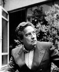 Octavio Paz: Retrato em preto e branco de um homem de meia-idade vestindo terno em um ambiente externo com folhagem ao fundo.