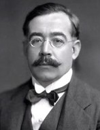 António Sérgio: Retrato em preto e branco de um homem com óculos redondos, bigode farto e gravata borboleta.