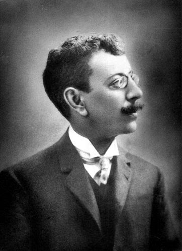 Olavo Bilac: Retrato vintage em preto e branco de um homem de perfil usando óculos, bigode e terno.