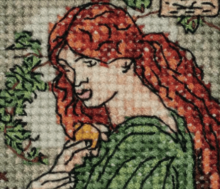 Detalhe de um bordado em ponto cruz retratando uma mulher ruiva com vestido verde, baseada em arte pré-rafaelita.