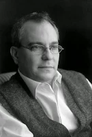 Gonçalo M. Tavares: Retrato em preto e branco de um homem usando óculos, camisa branca e um colete.