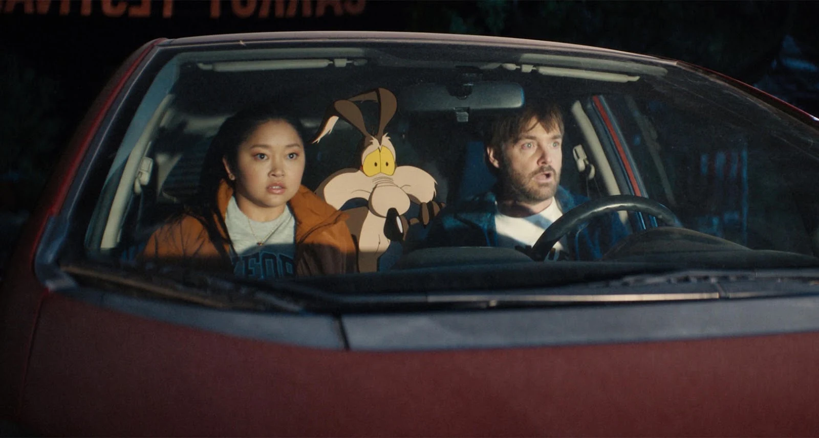 Coyote vs. Acme Lana Condor, Will Forte: Uma cena do filme Coyote vs. Acme mostrando dois atores e o personagem de animação Wile E. Coyote dentro de um carro.