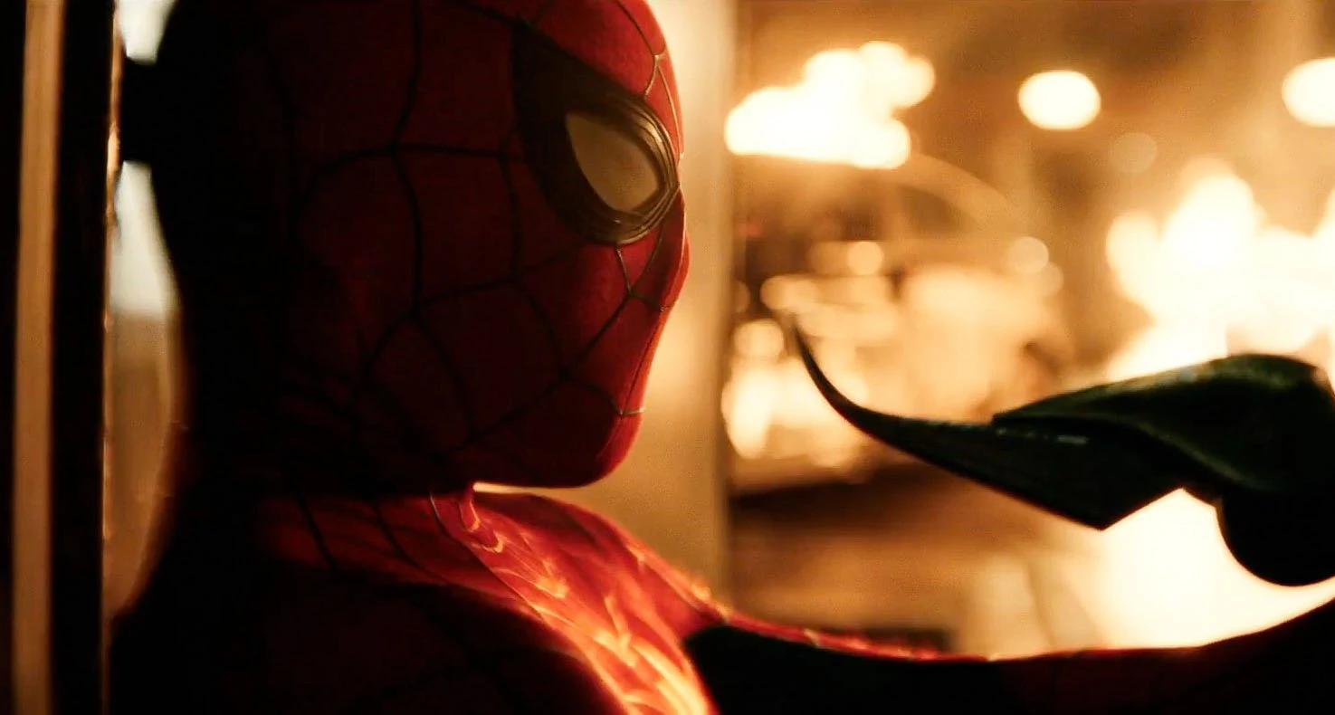 Spider-Man: Close-up do Homem-Aranha em perfil contra um fundo iluminado por fogo.