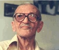 Chico Xavier: Retrato de um homem idoso com óculos de armação escura e bigode.