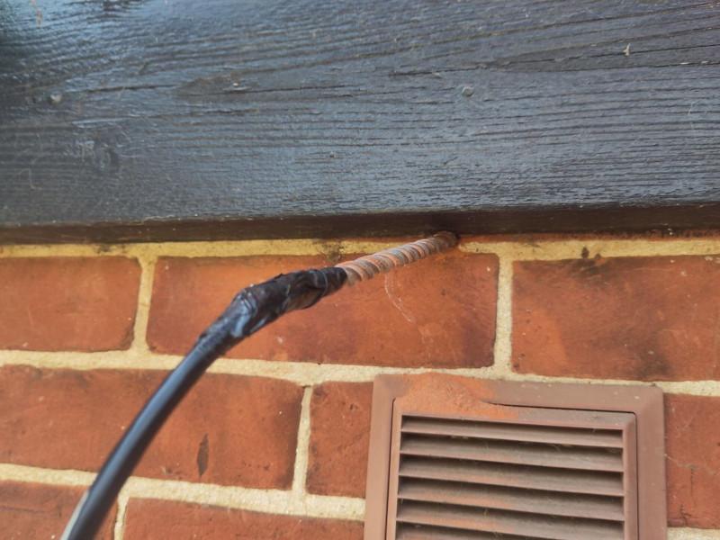 Photo of the end of some armoured ethernet cable duct-taped onto the end of a drill bit