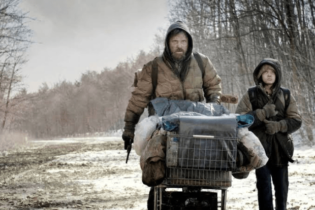 Viggo Mortensen, Kodi Smit-McPhee: Uma cena do filme 'A Estrada' (The Road) mostrando um homem e uma criança caminhando em um cenário pós-apocalíptico com um carrinho de compras.