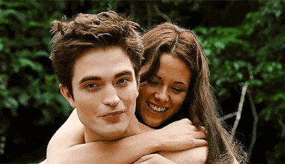 Robert Pattinson e Kristen Stewart: Uma fotografia de cena de filme mostrando Edward Cullen e Bella Swan abraçados na floresta.
