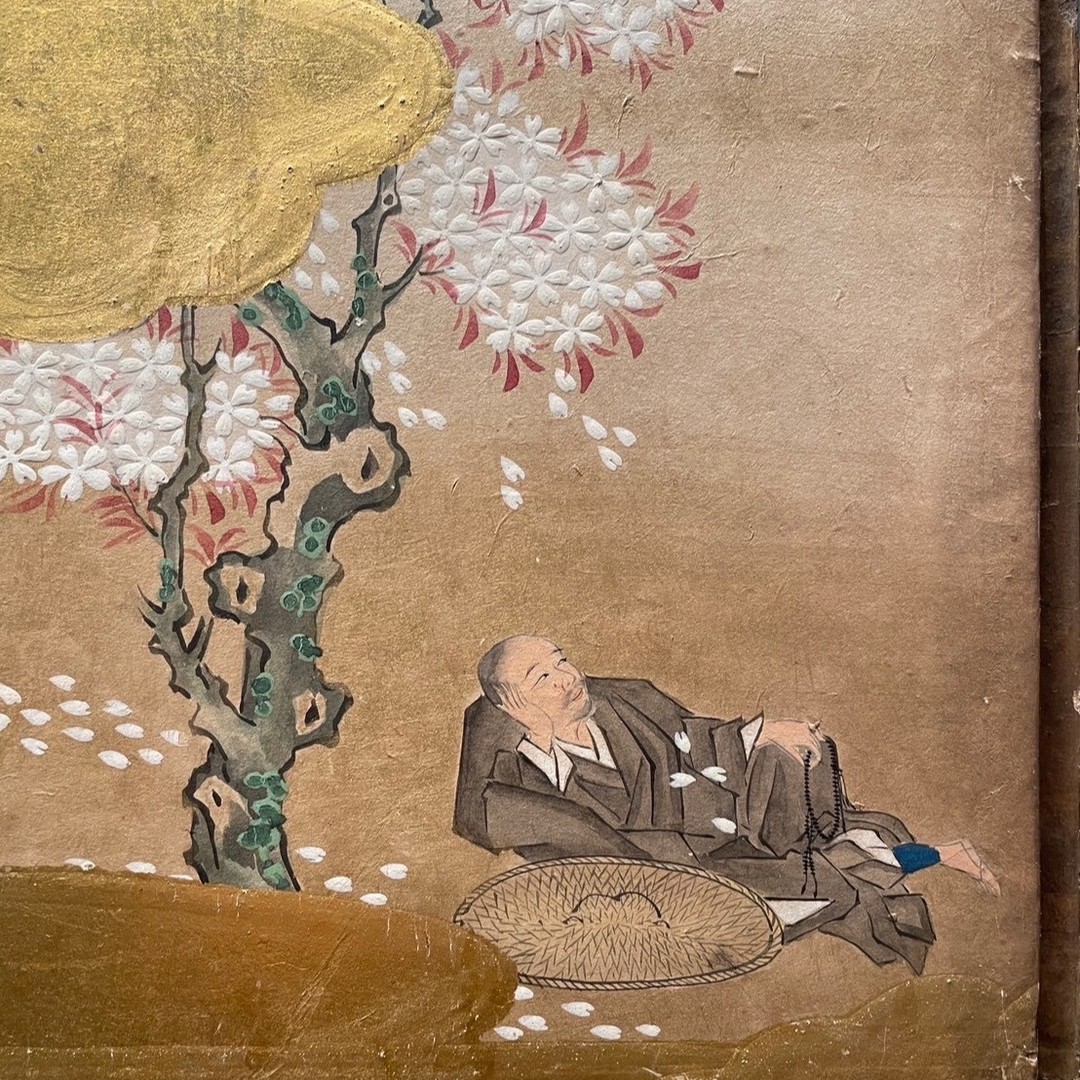 unknown: Uma pintura tradicional japonesa em papel ou seda retratando um homem descansando sob uma árvore de cerejeira em flor.